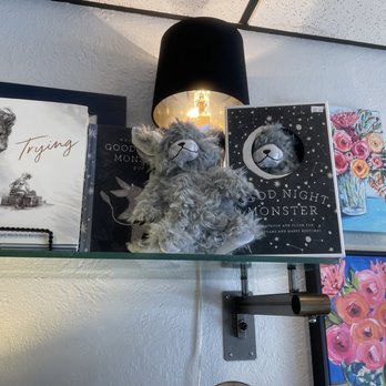 Dara Marie's - a shelf with books and a teddy bear - Bakeries Near Me - Norman, Oklahoma