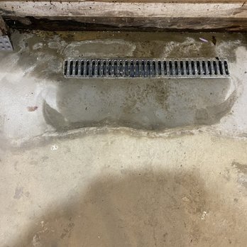 Basements Love Us - If the grate were longer or there was a trench created to make the water go into the grate this wouldn't be an issue - Waterproofing Near Me Basements Love Us - If the grate were longer or there was a trench created to make the water go into the grate this wouldn't be an issue - Waterproofing Near Me