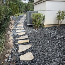Eden flag stone path and flat slate rock add beauty to a hidden French drain system below grade.