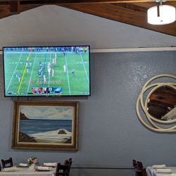 D Monaghan's On the Hill - Main dining room, wires exposed all around a tv above an uncentered painting.