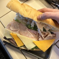 Save Mart - Pre-prepared large sandwich from the deli with half sliced cheese positioned in a way to make sandwich appear to have full slices.