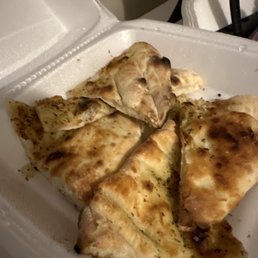 a white styrofoam container with four slices of pizza in it