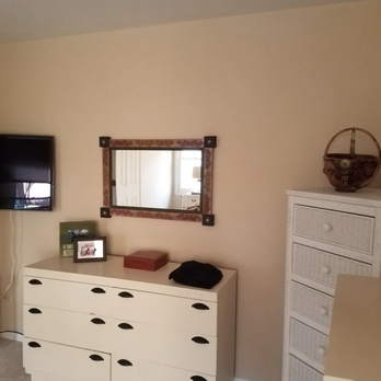 AYR Home Services - a bedroom with a dresser, mirror, and television - General Contractors Near Me - Glenview, Illinois