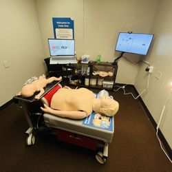 Code One CPR Training - Practice manikins for compressions and ventilations competency check with live coach on laptop.
