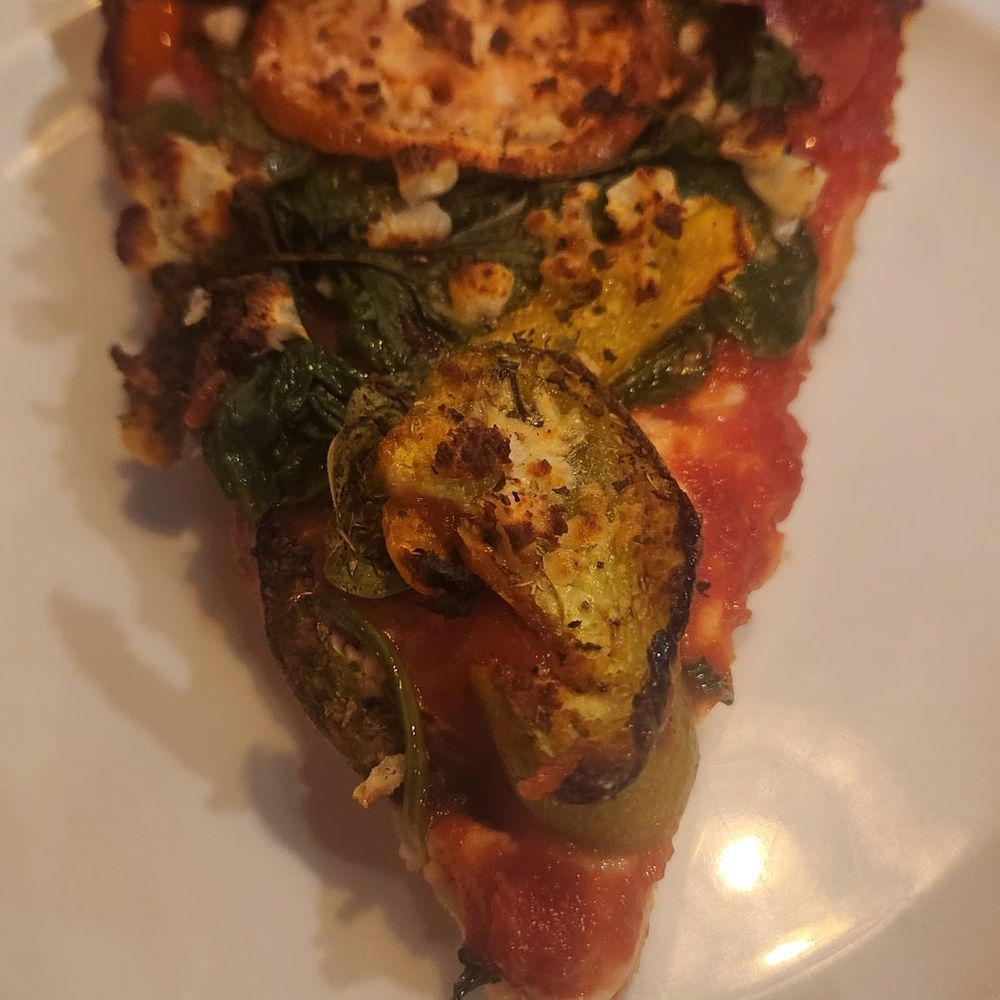Slice of deep dish with lots of toppings