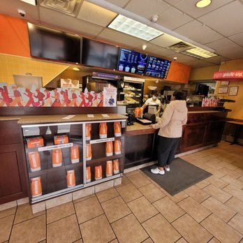 Dunkin' - a woman standing at the counter of a dunkin donuts restaurant - Donuts Near Me - College Point, New York Dunkin' - a woman standing at the counter of a dunkin donuts restaurant - Donuts Near Me - College Point, New York