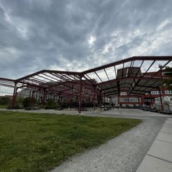 Spielplatz am Lokschuppen - Früher war hier ein Lokschuppen, an den die Stahlkonstruktion erinnert. Das gerippte Dach spendet im Sommer Schatten (September 2023)