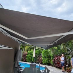 Harrison Awnings - 22' Motorized SunPro Brand Retractable Awning with a White frame and gray fabric by Sunbrella - in Wilton Manors
