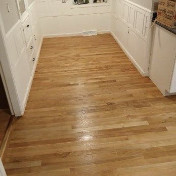 Wayne Mounce - a kitchen with white cabinets and wood floors - Flooring Near Me