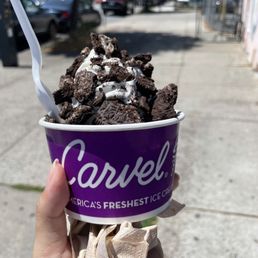 a hand holding a cup of ice cream a hand holding a cup of ice cream