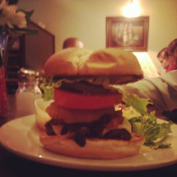 Bradden's - River Cafe burger stacked high with BBQ sauce, bacon, onion ring, lettuce and tomato. - New American Near Me - Saint Charles, Missouri Bradden's - River Cafe burger stacked high with BBQ sauce, bacon, onion ring, lettuce and tomato. - New American Near Me - Saint Charles, Missouri