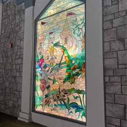 The beautiful stained glass window at the front.