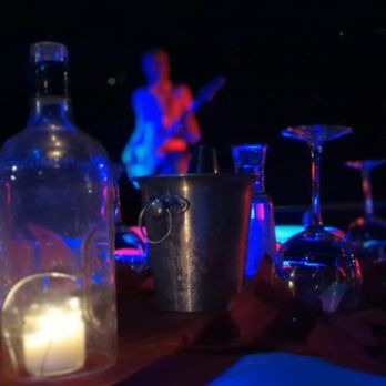 Floating Tavern - a candle and a bottle on a table - Tapas/Small Plates Near Me - Austin, Texas Floating Tavern - a candle and a bottle on a table - Tapas/Small Plates Near Me - Austin, Texas