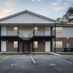 Seasons Apartments - A two-story apartment building with a parking lot in front