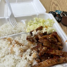 a plate of rice, meat, and coleslaw a plate of rice, meat, and coleslaw