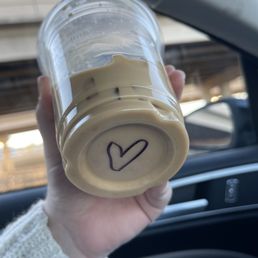 a person holding a cup with a heart drawn on it