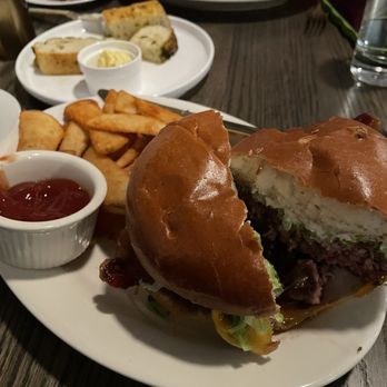 Elsie’s Table - Burger - A burger with a toasted bun, beef patty, lettuce, and other toppings, served with fries, ketchup, and potato wedges at Elsie's Table. - New American Near Me - Canton, Massachusetts