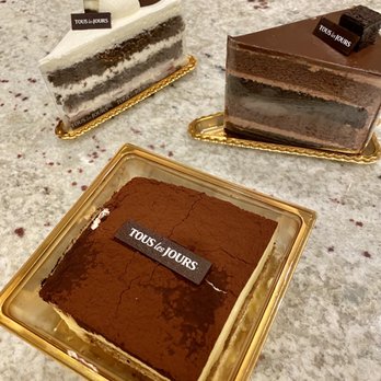 Tous Les Jours - Front: Tiramisu. Left: chocolate & cream cake. Right: chocolate mousse cake. - Coffee & Tea Near Me - Chicago, Illinois Tous Les Jours - Front: Tiramisu. Left: chocolate & cream cake. Right: chocolate mousse cake. - Coffee & Tea Near Me - Chicago, Illinois