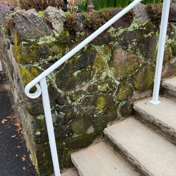 A1 On Time Construction LLC - BEFORE--Left of stairs, crumbling and eroded stone wall, water leaking through - General Contractors Near Me