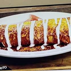 Taqueria Lago Azul - A burrito covered in salsa, served on a plate and mainly eaten with a fork.