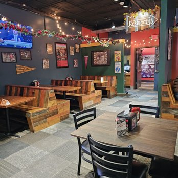 Allsports Cafe Salem - A seating area in the back of the restaurant and a sign pointing to the location of the restrooms. - Sports Bars Near Me - Salem, Virginia