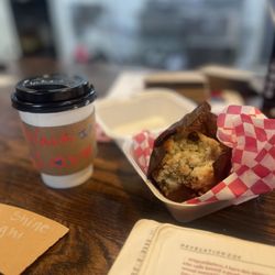 She Brews Coffee Roasters - Black coffee and a blueberry muffin