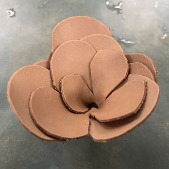 Rochambeau Library - molded 3-D leather rose - A three-dimensional leather rose sculpture with layered petals, created through molding techniques, placed on a flat surface. - Libraries Near Me - Providence, Rhode Island
