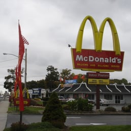 a mcdonald's sign in front of a mcdonald's restaurant
