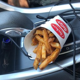 french fries in a paper cup in the center console of a car french fries in a paper cup in the center console of a car