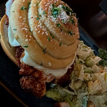 Primo's - Chicken Parmesan sandwich with a garlic bread roll with the side of a Caesar salad - Salad Near Me - San Antonio, Texas Primo's - Chicken Parmesan sandwich with a garlic bread roll with the side of a Caesar salad - Salad Near Me - San Antonio, Texas
