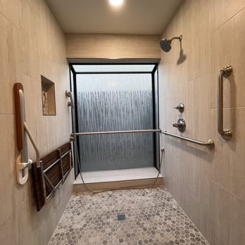 Luxehome Construction - AFTER: Curbless roll-in shower with grab bars, foldable shower seat, and reconfigured/relocated accessible shower fixtures. - General Contractors Near Me - Rancho Cordova, California