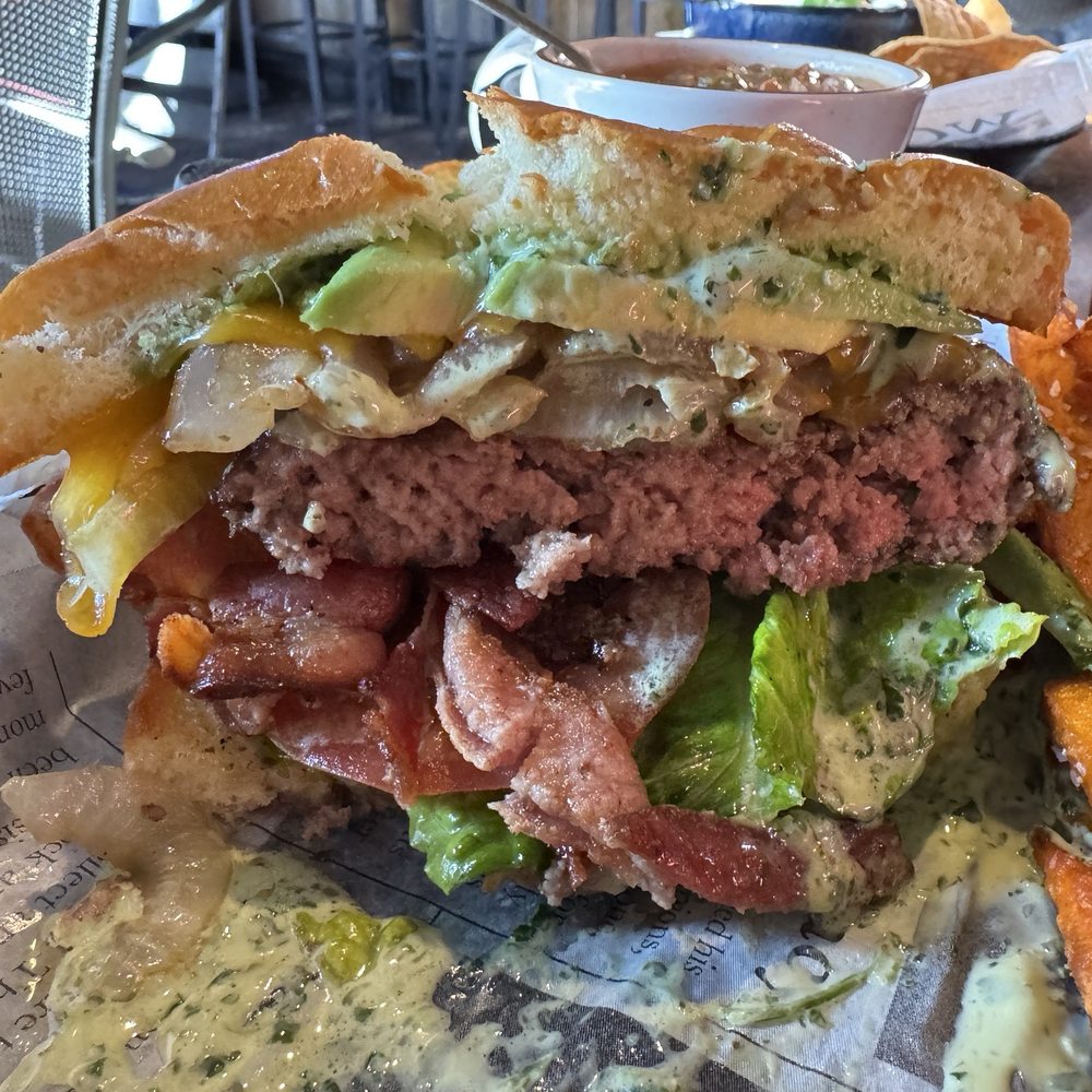 The burger with bacon, cilantro crema, avocado, grilled onions & sweet potato fries. YUM!
