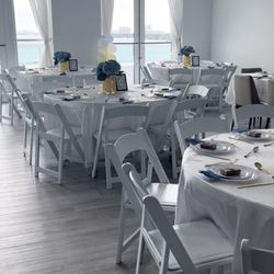 JC Party Rentals - Round tables, white padded resin chairs, and white table linens