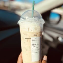 a hand holding a cup of iced coffee