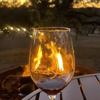 Barons CreekSide - Enjoying a glass of wine near the fire pit at The Club - Guest Houses Near Me - Fredericksburg, Texas