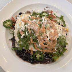 Nudy’s - Huevos Rancheros: over easy eggs atop crispy hash browns, black beans, shredded lettuce and jalapeño w/a lime cilantro sour cream drizzle.