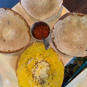 Banana Leaf - Hoppers 3 Plain + 1 Egg Delicate, bowl-shaped pancakes made with fermented rice flour and coconut milk. Served with katta sambol. Incl - Sri Lankan Near Me - Manassas, Virginia Banana Leaf - Hoppers 3 Plain + 1 Egg Delicate, bowl-shaped pancakes made with fermented rice flour and coconut milk. Served with katta sambol. Incl - Sri Lankan Near Me - Manassas, Virginia