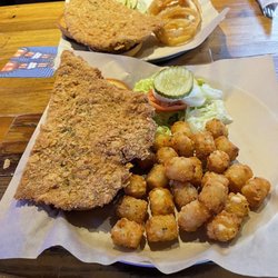 Crusens - Pork Tenderloin Sandwich Half order.  One with onion rings & the other with Tator Tots.