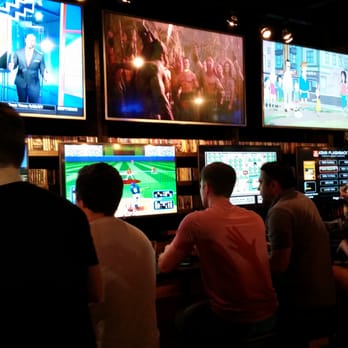 16-Bit Bar+Arcade - The screens to the right of the entrance, prominently displaying games from the Atari 2600 to the NES as well as TV and movies. - Bars Near Me - Cincinnati, Ohio 16-Bit Bar+Arcade - The screens to the right of the entrance, prominently displaying games from the Atari 2600 to the NES as well as TV and movies. - Bars Near Me - Cincinnati, Ohio