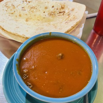 Duran Central Pharmacy - Bowl of red chile with beef and homemade buttered tortilla - Mexican Near Me - Albuquerque, New Mexico