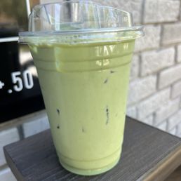 a green drink in a plastic cup a green drink in a plastic cup