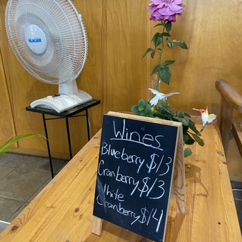 Blue Heron Winery - a table with a sign and a fan - Wineries Near Me - Pitt Meadows, British Columbia