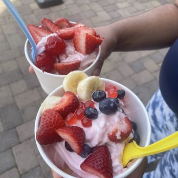 Nubi Yogurt - a person holding two bowls of yogurt with strawberries, bananas, and blueberries - Ice Cream & Frozen Yogurt Near Me - Moreno Valley, California