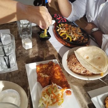 La Fogata - a man pouring a beer over a plate of food - Latin American Near Me - Miami, Florida La Fogata - a man pouring a beer over a plate of food - Latin American Near Me - Miami, Florida