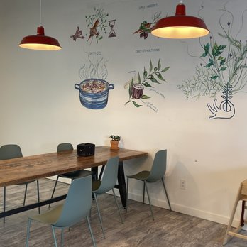 Springbone Kitchen - a table and chairs in front of a mural - Soup Near Me - Millburn, New Jersey