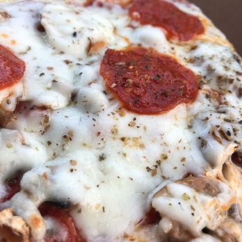 Ralph’s Nino's Pizzeria - a hand holding a piece of pizza - Pizza Near Me - Peoria, Arizona Ralph’s Nino's Pizzeria - a hand holding a piece of pizza - Pizza Near Me - Peoria, Arizona