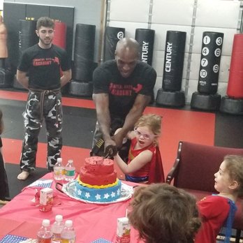 Field Martial Arts Academy - Wonder Woman cuts the cake with a sword for her 5th birthday. SUPER!! - Martial Arts Near Me - Norwood, Massachusetts Field Martial Arts Academy - Wonder Woman cuts the cake with a sword for her 5th birthday. SUPER!! - Martial Arts Near Me - Norwood, Massachusetts