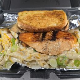 Shrimp fettuccine alfredo with a piece of salmon and garlic bread Shrimp fettuccine alfredo with a piece of salmon and garlic bread