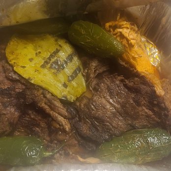 El Pollo Cris Cris - Pollo and Skirt steak al carbon - A foil container holds grilled steak, jalapeños, and vegetables, likely from a Mexican restaurant specializing in grilled meats and traditional dishes. - Mexican Near Me - Chicago, Illinois