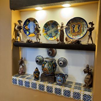 Casa Del Lago  -  shelf with decorative plates and figurines - Mexican Near Me - Granite Bay, California